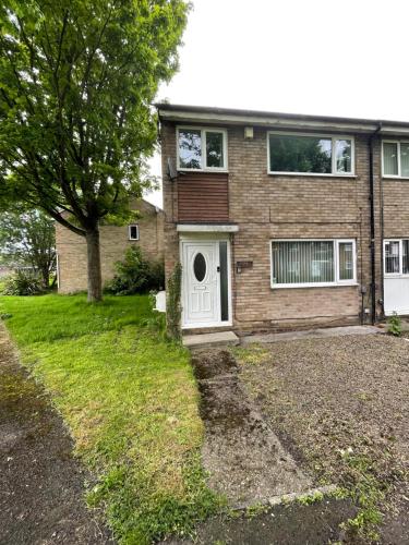 a brick house with a white door and a tree at Redcroft Green 3 Bdrm Sleeps 5 Quiet Residental Area in Newcastle upon Tyne