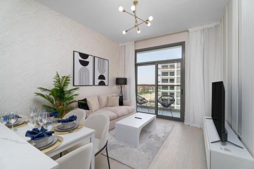 a white living room with a couch and a tv at Nasma Luxury Stays - Laya Heights in Dubai