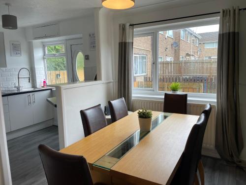 a kitchen and dining room with a wooden table and chairs at Redcroft Green 3 Bdrm Sleeps 5 Quiet Residental Area in Newcastle upon Tyne