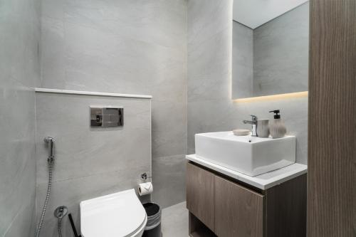 a bathroom with a white sink and a toilet at Nasma Luxury Stays - Laya Heights in Dubai