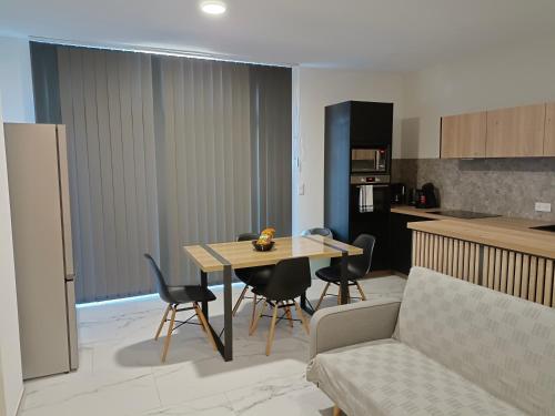 ein Wohnzimmer und eine Küche mit einem Tisch und Stühlen in der Unterkunft Les Sables Blancs de la Liscia in Calcatoggio