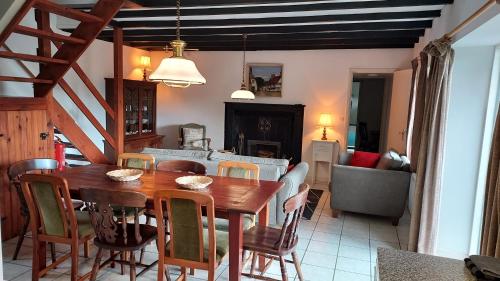 uma cozinha e sala de jantar com uma mesa de madeira e cadeiras em Domaine Armorica em La Chapelle-Neuve