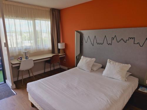a hotel room with a bed and a desk at Kyriad Carcassonne - Aéroport in Carcassonne