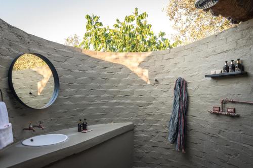 uma casa de banho com um lavatório e uma parede de tijolos em Africa on Foot em Reserva Natural Privada de Klaserie