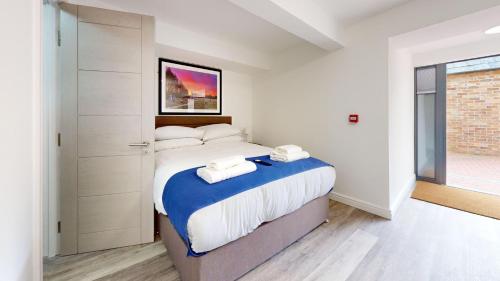 - une chambre avec un grand lit et des serviettes dans l'établissement Bicester Court Lodge The Langford Room, à Bicester