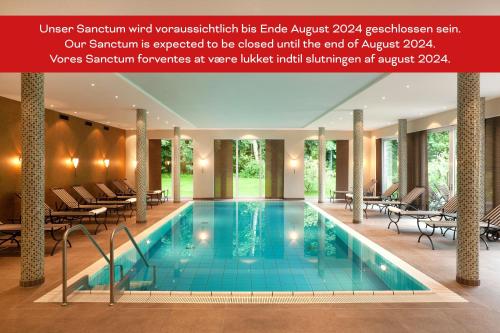 a hotel swimming pool with chairs and tables at Romantik Hotel Kieler Kaufmann in Kiel