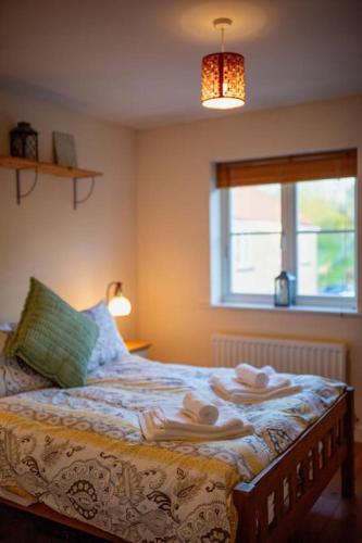 a bedroom with a bed with towels on it at Marley's Coach House - Frome in Frome