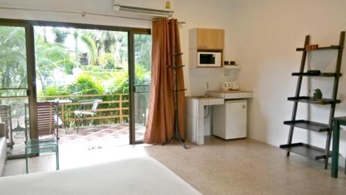 a kitchen with an open door to a patio at Escape-Cabins in Ko Lanta