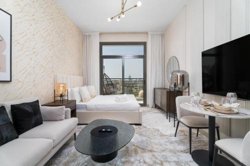 a living room with a couch and a bed and a table at Nasma Luxury Stays - Laya Heights in Dubai