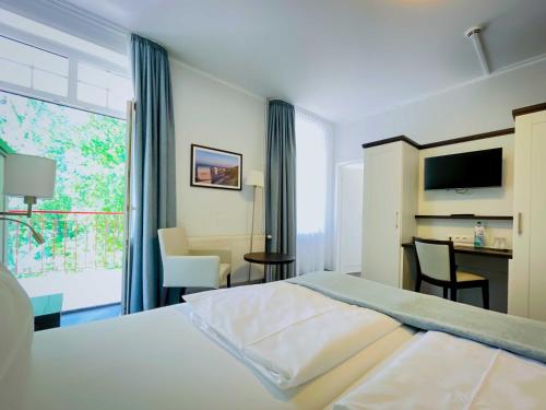 Habitación de hotel con cama, mesa y sillas en Strandhotel Graal-Müritz, en Graal-Müritz