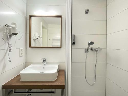 a bathroom with a sink and a shower at Strandhotel Graal-Müritz in Graal-Müritz