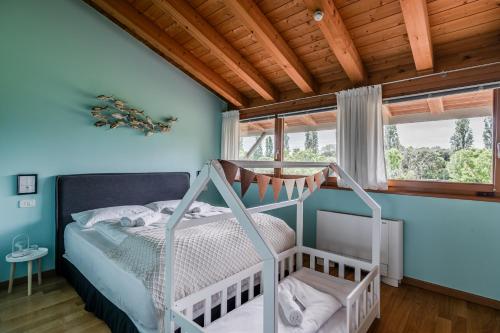 a bedroom with a bed and a wooden ceiling at TOCAI Golf & Family Retreat Lignano in Lignano Sabbiadoro