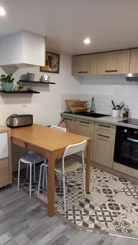 - une cuisine avec une table en bois, des chaises et un évier dans l'établissement Appartement individuel en maison, à Beaumont-sur-Oise