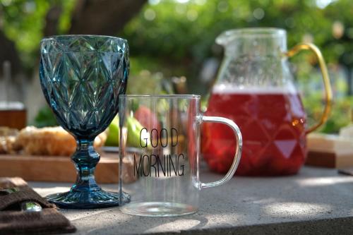 zwei Glasbecher und eine Vase auf dem Tisch in der Unterkunft Khoreayi Dzor in Goris