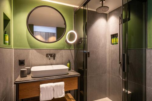 bagno con lavandino e specchio di Hotel ZERMAMA Zermatt a Zermatt