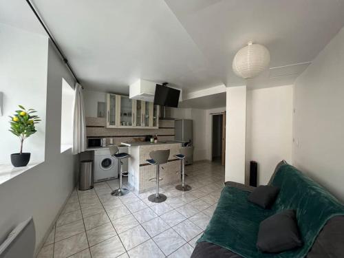 un salon avec un canapé et une cuisine dans l'établissement Appartement au cœur de La Garde Adhémar, à La Garde-Adhémar