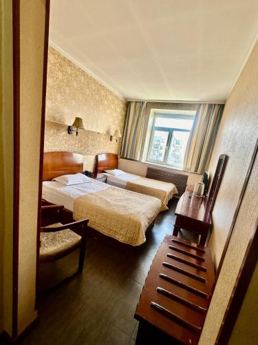 a hotel room with two beds and a window at Kharaa Hotel & Restaurant in Ulaanbaatar