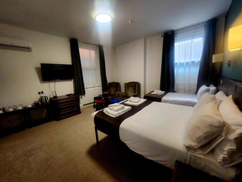 a hotel room with a large bed and a television at Keppels Head Hotel in Portsmouth
