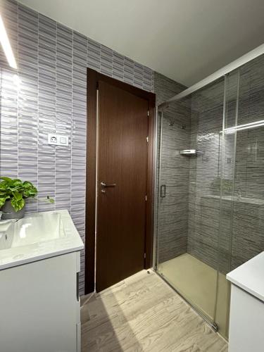 a bathroom with a shower and a glass door at Villa los corzos in Oviedo