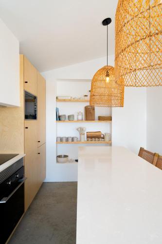 a kitchen with white counters and a white counter top at Casa Bartolomeu in Castro Marim