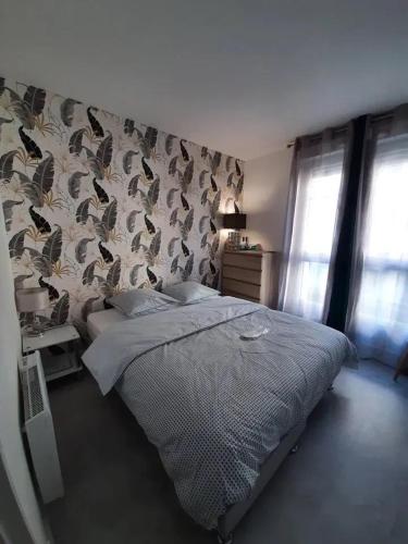 a bedroom with a bed and a wall with bird wallpaper at Appartement d'une chambre avec vue sur la ville terrasse amenagee et wifi a Saint Germain en Laye in Saint-Germain-en-Laye