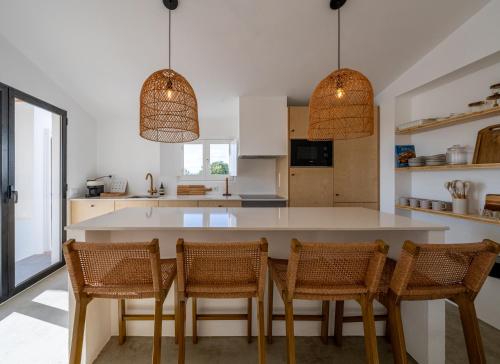 a kitchen with a large white table and chairs at Casa Bartolomeu in Castro Marim