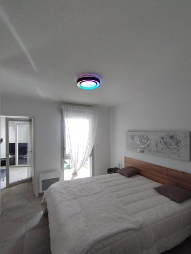 - une chambre avec un grand lit et une lumière bleue dans l'établissement ALBI ville T2 Confortable et moderne, à Albi