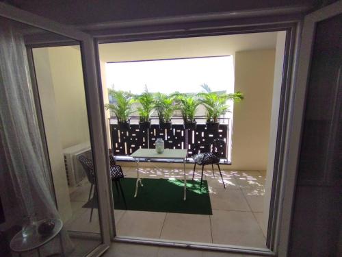 - un balcon avec une table et des palmiers dans l'établissement ALBI ville T2 Confortable et moderne, à Albi