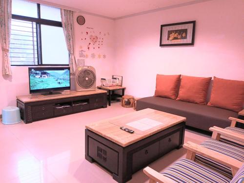 a living room with a couch and a tv at Yun Cheng Homestay in Jiufen