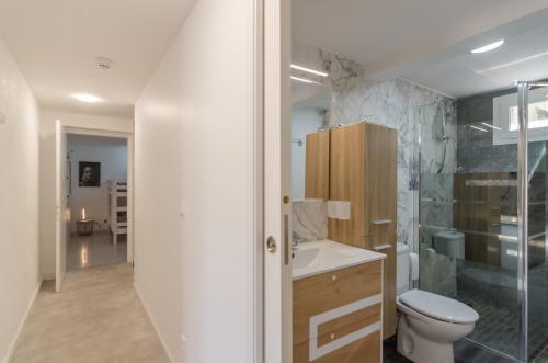 uma casa de banho com um WC e uma cabina de duche em vidro. em Club Villamar - Hestia em Lloret de Mar
