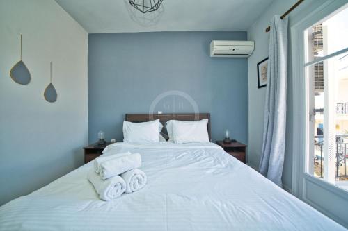a bedroom with a white bed with towels on it at Ira Apartment in Ermioni