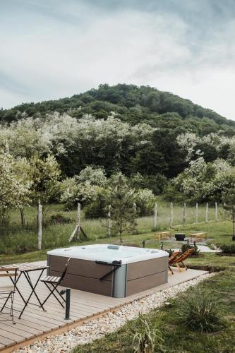 a pool on a wooden deck with a mountain in the background at Békés Bucka Mátra in Parád