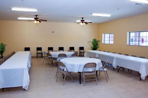 a room with tables and chairs with white table cloth at Guest Inn San Benito/Harlingen in San Benito