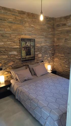 a bedroom with a bed with a stone wall at AegeanDeepBlue2 in Apróvaton
