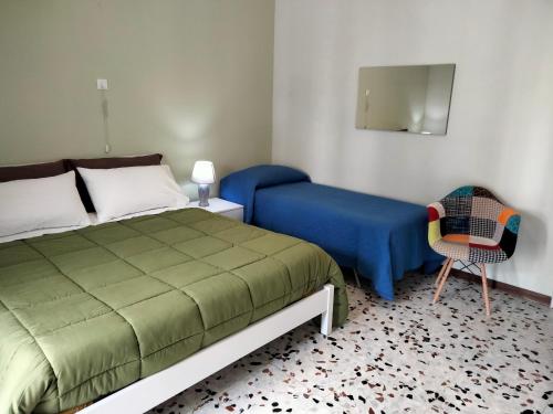 a bedroom with a bed and a chair and a mirror at La Castellina 23 in Sulmona