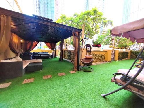 - un salon avec de l'herbe verte et une balançoire dans l'établissement ELAN RIMAL SADAF Suites, à Dubaï
