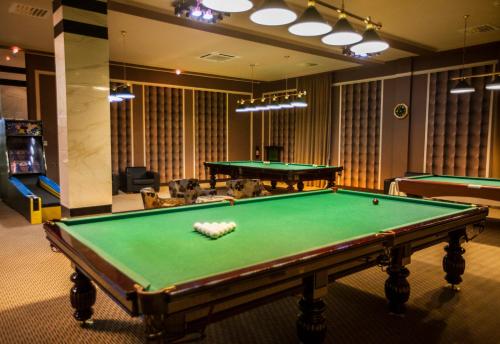 a pool table in a room with two tables at Gashalti Health Hotel Naftalan in Naftalan