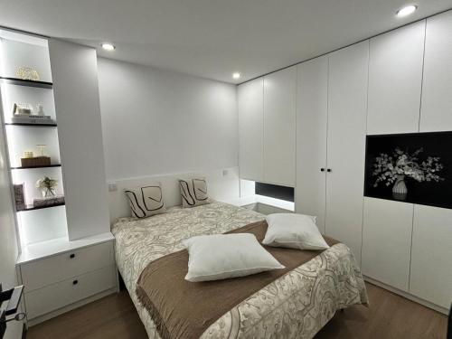 a bedroom with a bed and white cabinets at Pink House in Monção