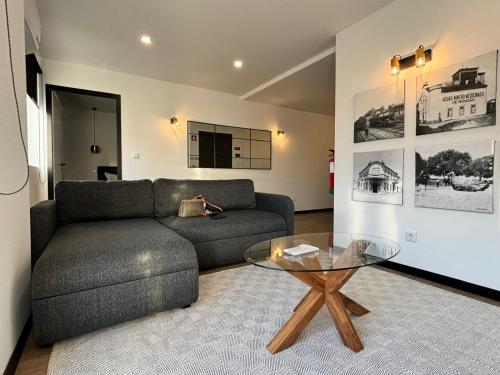 a living room with a couch and a glass table at Pink House in Monção