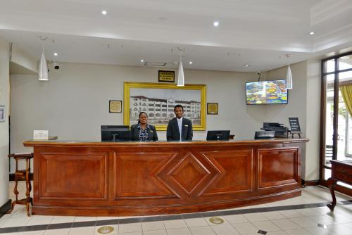 two men are standing at a reception desk at The Balmoral - Halaal in Durban