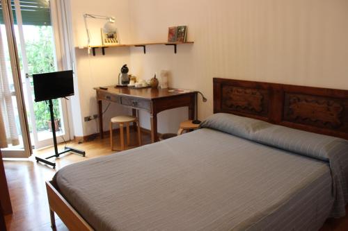 sypialnia z łóżkiem i biurkiem z komputerem w obiekcie Navigli w Mediolanie