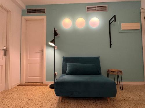 サンアントニオにあるAparthotel Boutique Poniente Playaの青いベッド1台、壁に照明が備わる客室です。