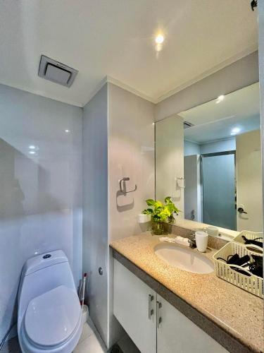 a bathroom with a toilet and a sink and a mirror at Kelsey's Homestay in Davao City