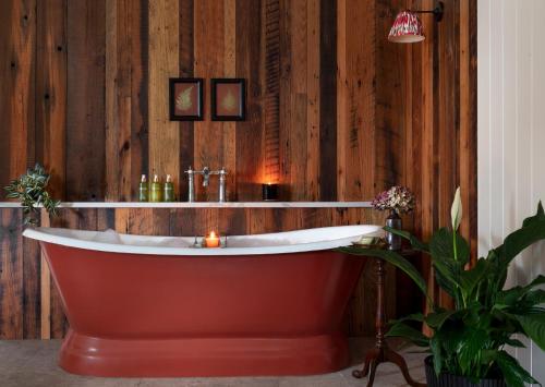 bañera en una habitación con pared de madera en The Ashe Hotel, en Tralee