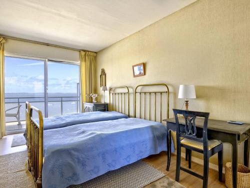 une chambre avec un lit, un bureau et une fenêtre dans l'établissement Arcachon Pereire - T2 Front de Mer avec Balcon et Parking - FR-1-433-26, à Arcachon