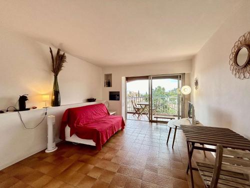 un salon avec un canapé rouge et une table dans l'établissement Studio avec Piscine, Parking et Terrasse à Sainte-Maxime - FR-1-226-420, à Sainte-Maxime