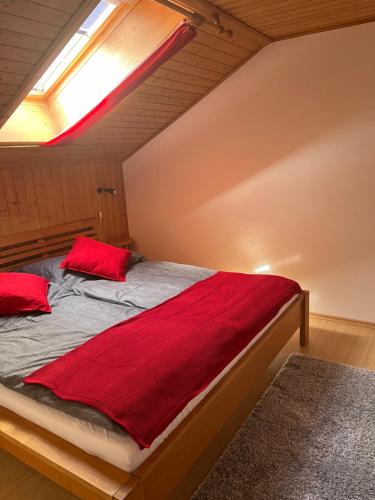 Un dormitorio con una cama con almohadas rojas. en Pferdehof Almgut en Faistenau