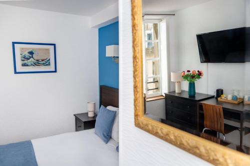a bedroom with a mirror and a room with a bed at Hotel Elizabeth - Intra Muros in Saint Malo