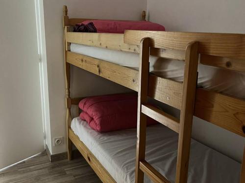 - un lit superposé avec 2 oreillers rouges dans l'établissement Appartement T2bis proche centre, 4-6 pers, parking - FR-1-234-297, à Cauterets