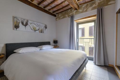 1 dormitorio con cama blanca y ventana en The View - Sunset & Relax - Suite - Appartamenti Vista Lago en Passignano sul Trasimeno